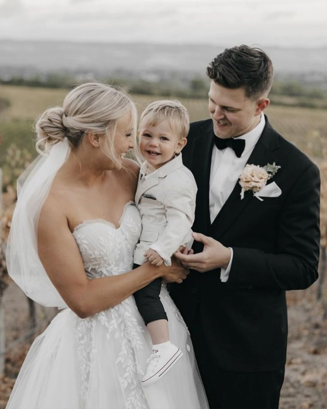 Couple with a baby and husband using a bespoke suit in a beautifull wedding