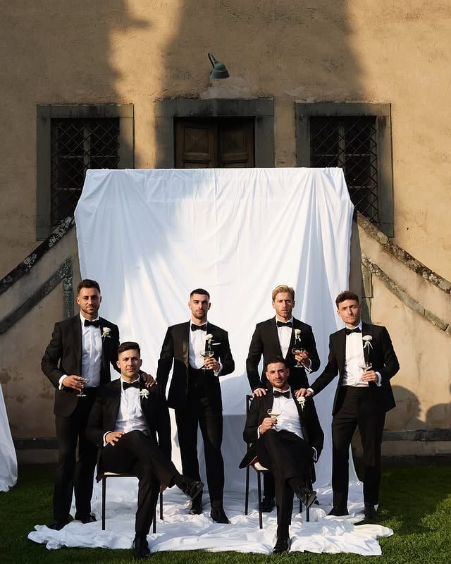 Groomsmen wearing matching Germanicos bespoke black tuxedos with satin peak lapels and elegant tailored silhouettes